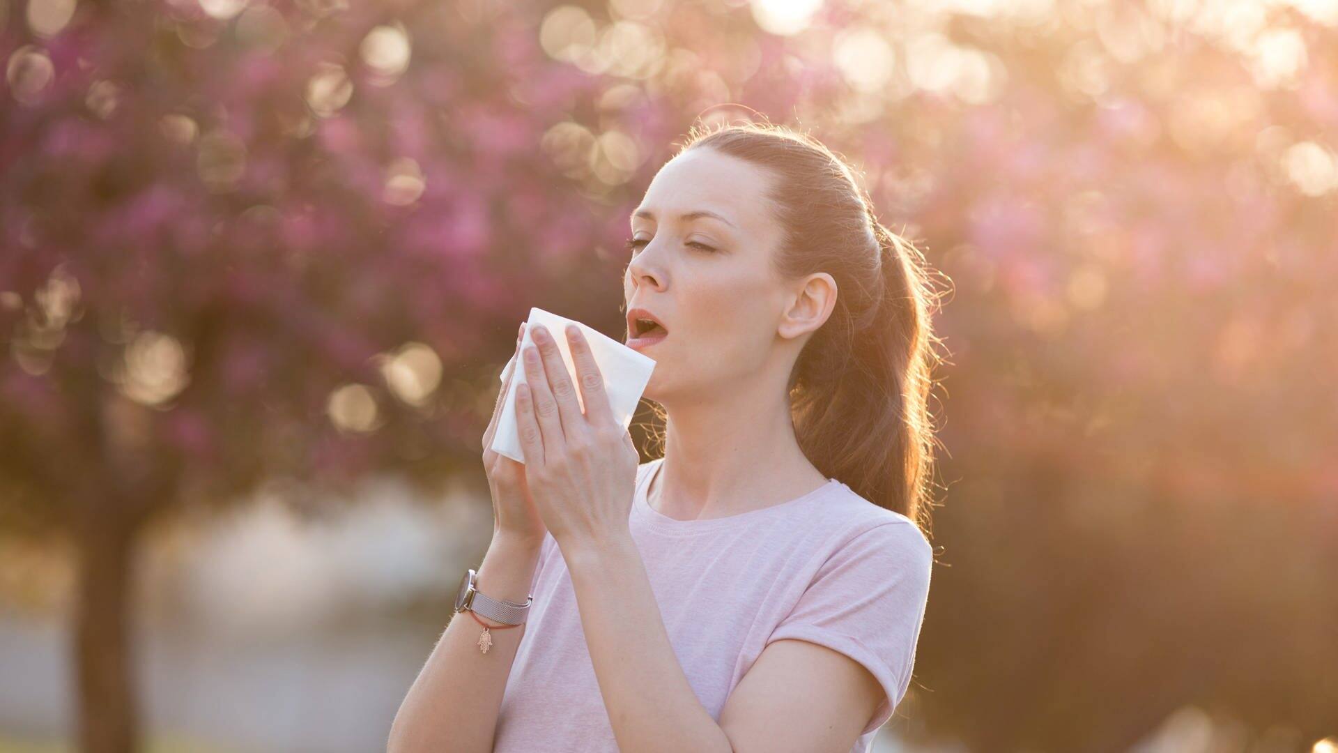 Frau niest, während sie ins Licht schaut (Foto: Adobe Stock/Budimir Jevtic)