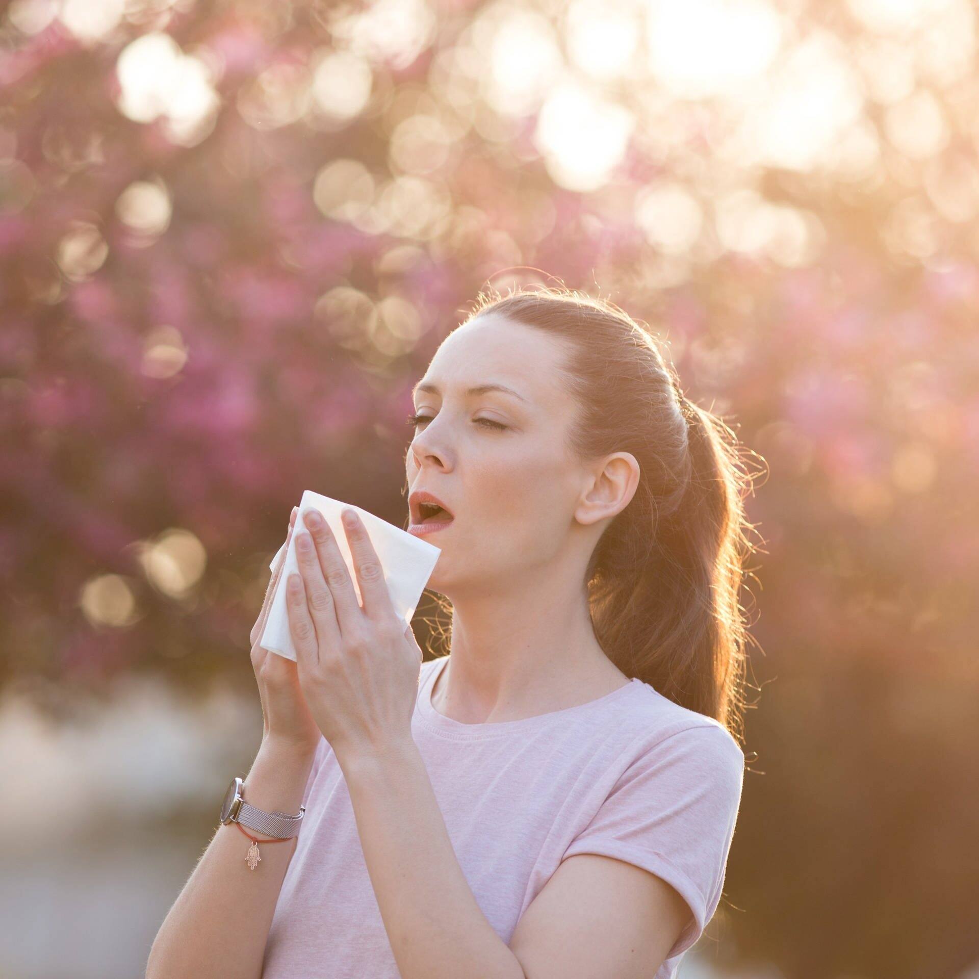 Frau niest, während sie ins Licht schaut (Foto: Adobe Stock/Budimir Jevtic)