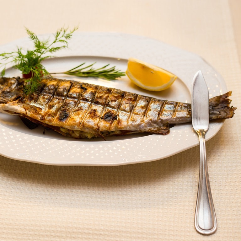 Gegrillte Forelle mit Fischbesteck (Foto: Adobe Stock/gertrudda)