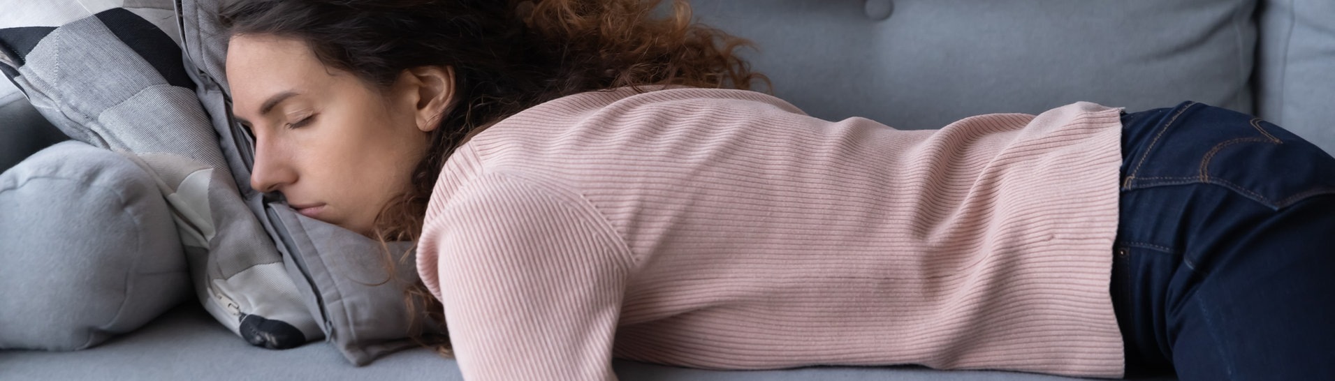 Junge Frau schläft erschöpft auf dem Sofa (Foto: Adobe Stock,  fizkes)