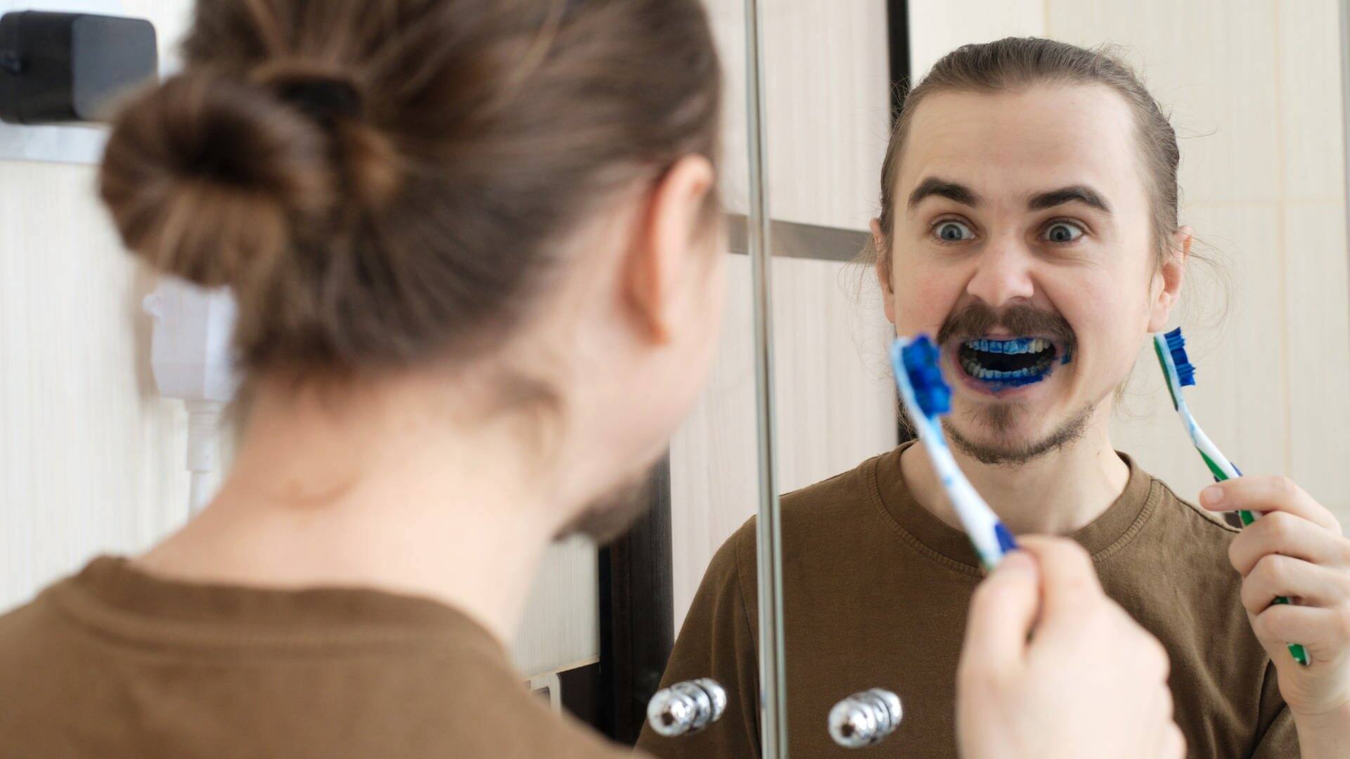 Aprilscherz: Mann erschreckt beim Zähneputzen mit blau gefärbter Zahncreme (Foto: Adobe Stock, aynur_sh)