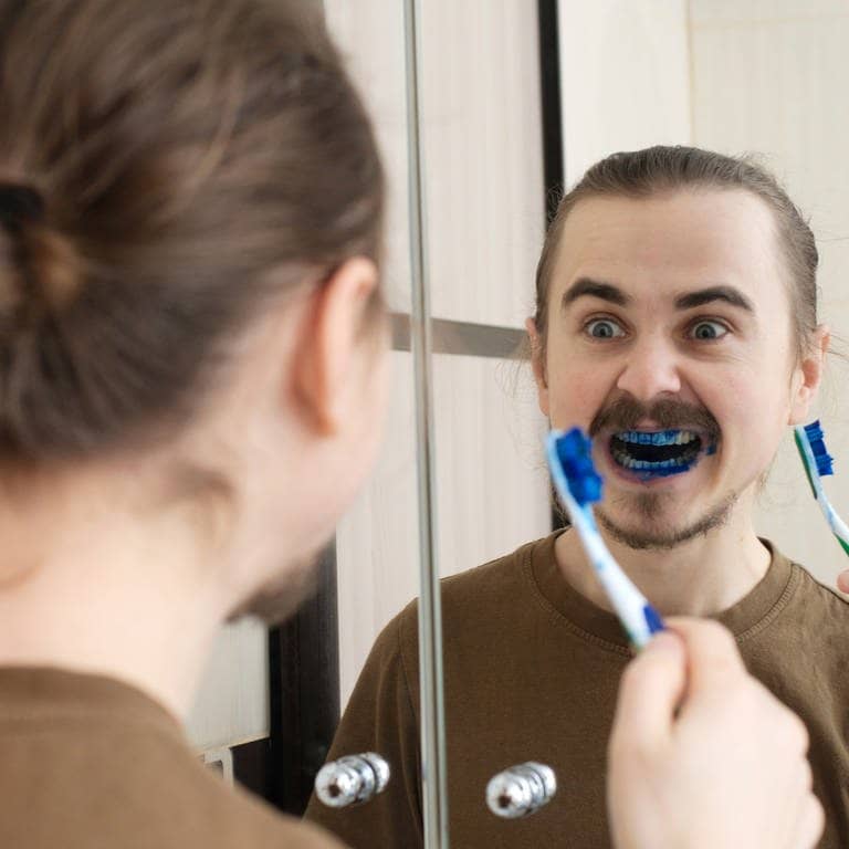 Aprilscherz: Mann erschreckt beim Zähneputzen mit blau gefärbter Zahncreme (Foto: Adobe Stock, aynur_sh)