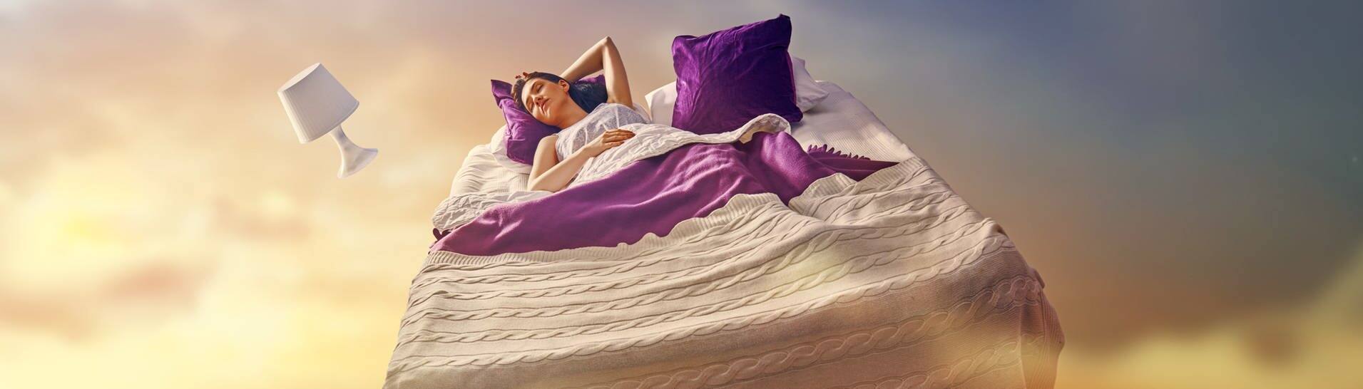 Mädchen liegt im Bett, dass im Himmel fliegt (Foto: Adobe Stock, Konstantin Yuganov)