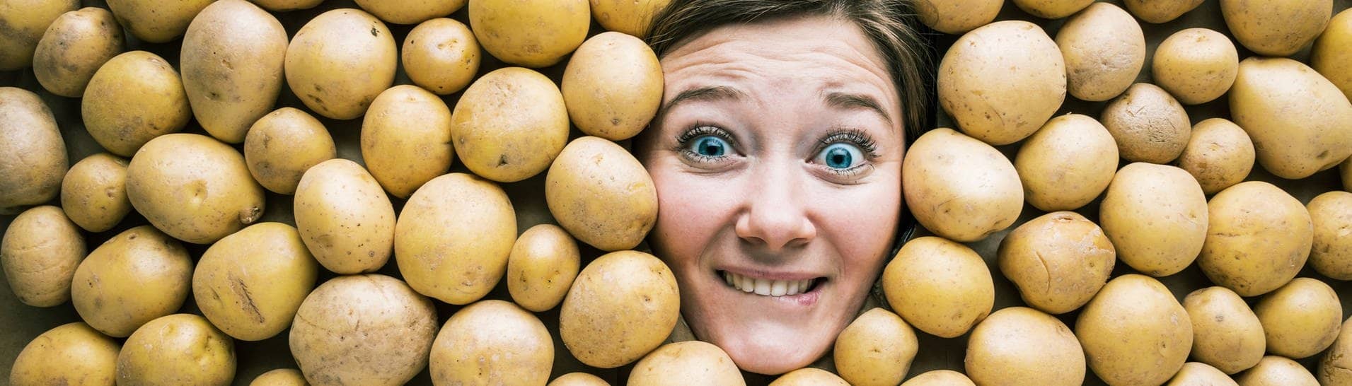 Gesicht einer Frau in einer Fläche aus Kartoffeln (Foto: Adobe Stock, karepa)