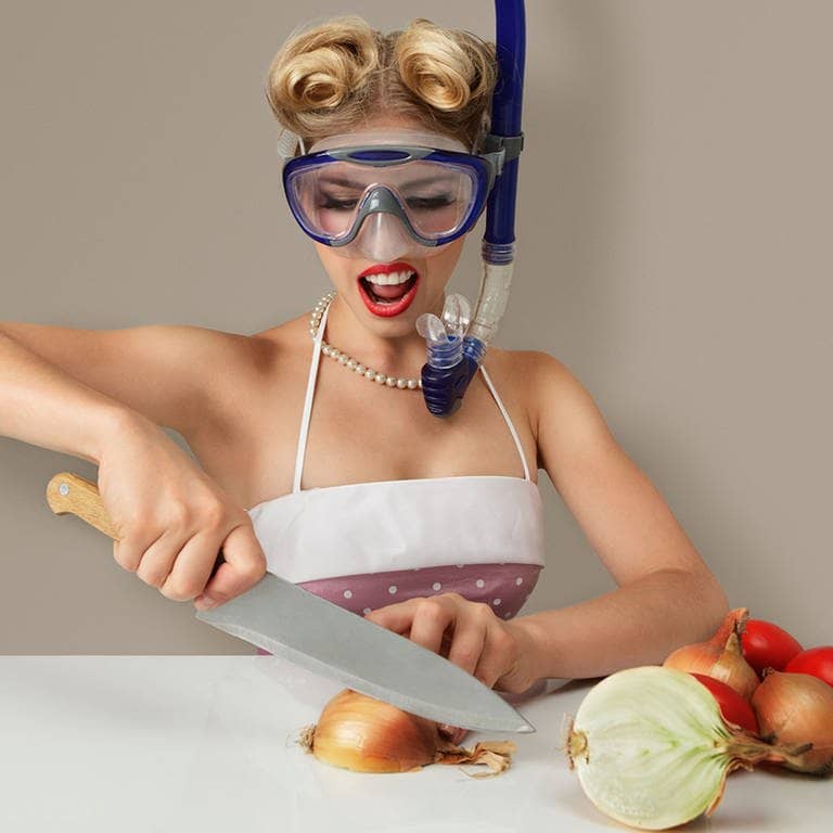 Frau mit Tauscherbrille schneidet eine Zwiebel 