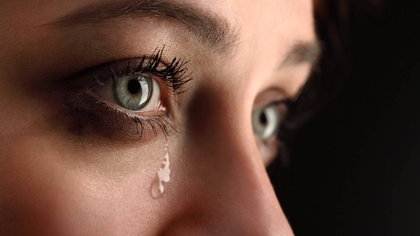 Frau mit grünen Augen weint dicke Tränen