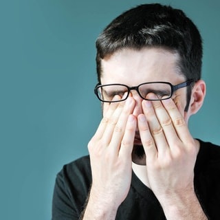 Mann reibt sich die Augen