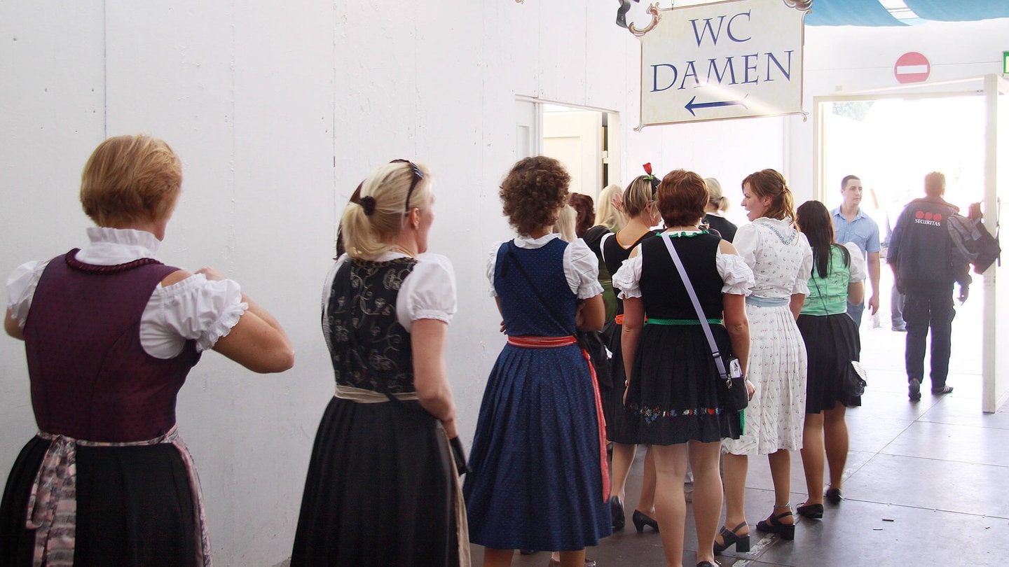 Frauen in einer Schlange zur Damentoilette