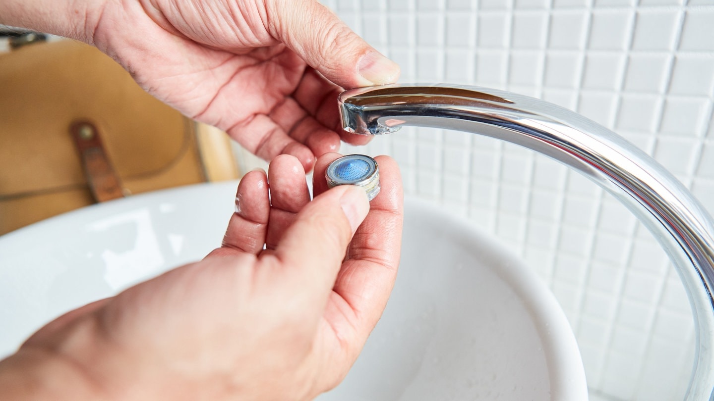 Installateur montiert sauberen Perlator am Wasserhahn (Foto: Adobe Stock/Robert Kneschke)