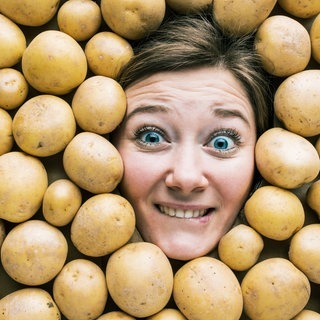 Gesicht einer Frau in einer Fläche aus Kartoffeln