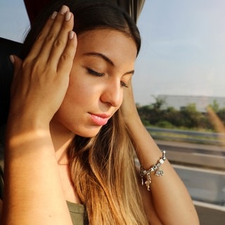 Junge Frau leidet an Übelkeit bei der Reise mit dem Bus.