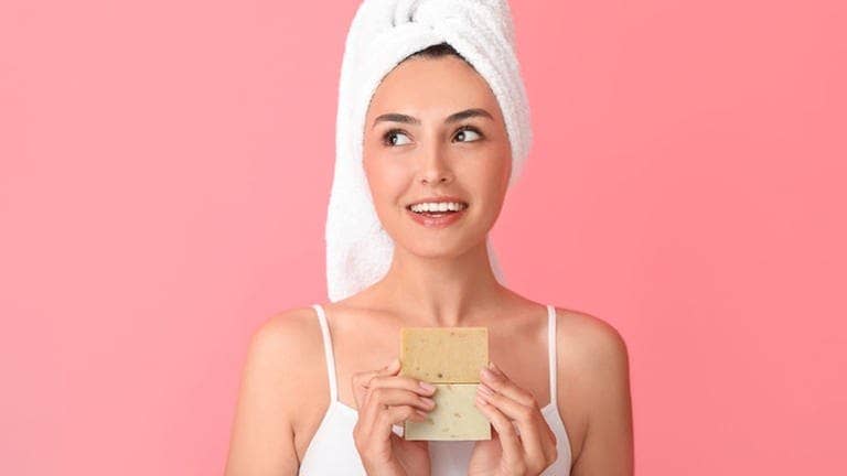 Eine junge Frau hält Seife in der Hand und fragt sich, ob wir wirklich Seife brauchen, um richtig sauber zu werden (Foto: Adobe Stock, Pixel-Shot)