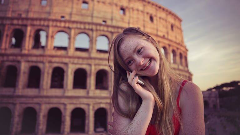 Das Tamara Röske vor dem Kolloseum in Rom telefoniert lächelnd mit einem Mobiltelefon. (Foto: Conny Wenk)