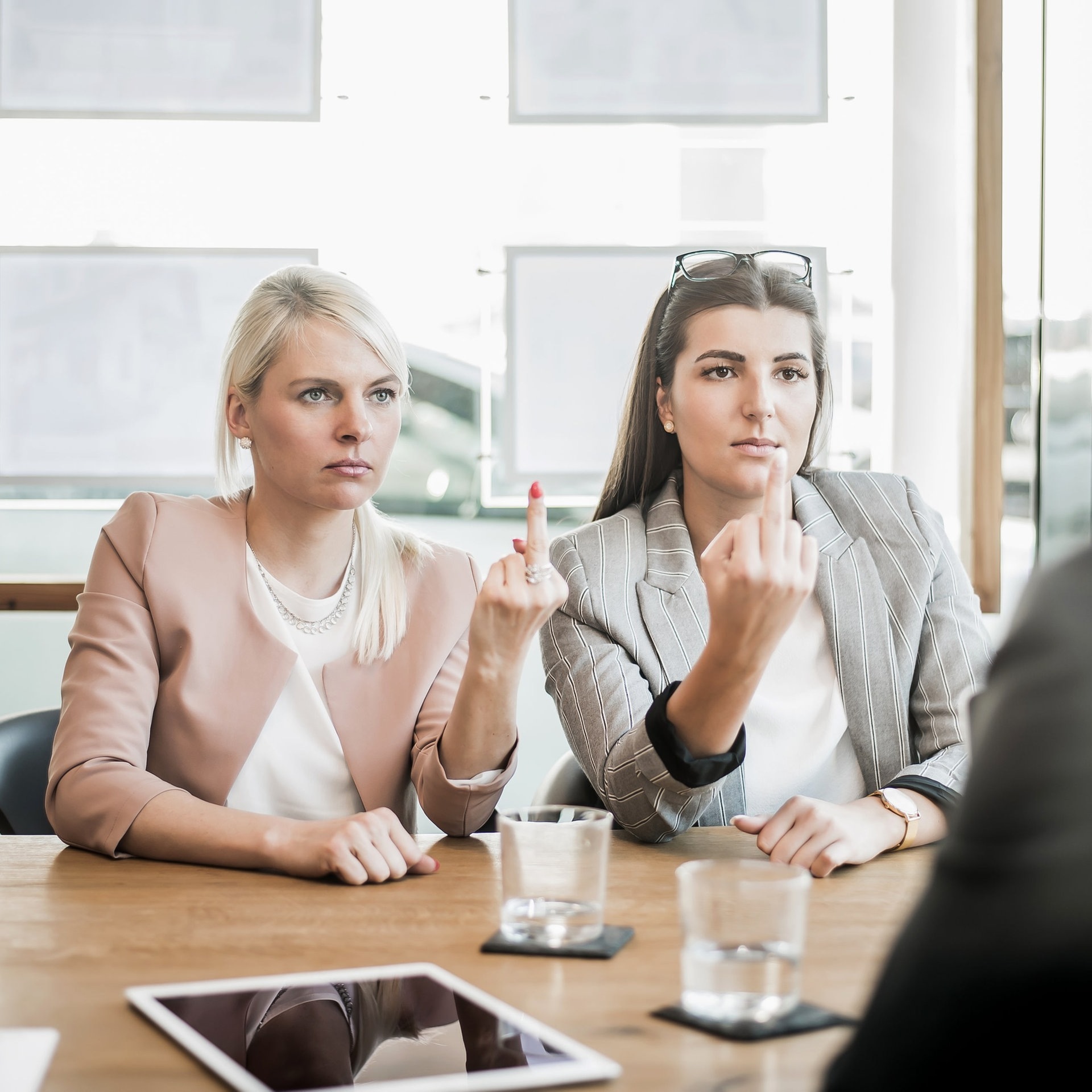Zwei Frauen zeigen ihrem Chef den Mittelfinger (Foto: Adobe Stock,  S.Kobold)