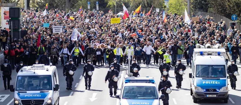 Ein Demonstrationszug der Bewegenung „Querdenken“ zieht durch Stuttgart. Polizisten sichern das Geschehen ab. (Foto: IMAGO, IMAGO / Nicolaj Zownir)