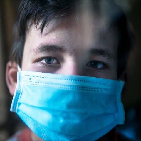 Ein trauriger Junge trägt eine Maske (Foto: IMAGO, Imago)