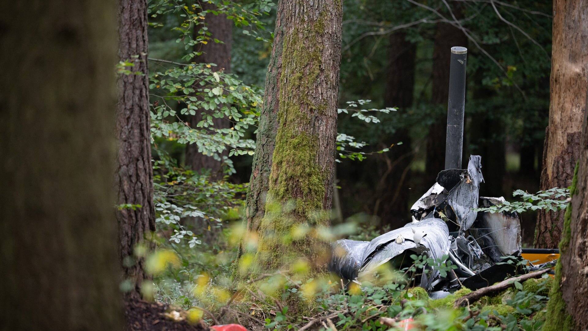 Trümmerteile des Hubschraubers vom Typ Robinson R44 und Feuerlöscher liegen in einem Wald bei Buchen nahe der Grenze zu Hessen und Bayern. (Foto: dpa Bildfunk, picture alliance/dpa | Sebastian Gollnow)