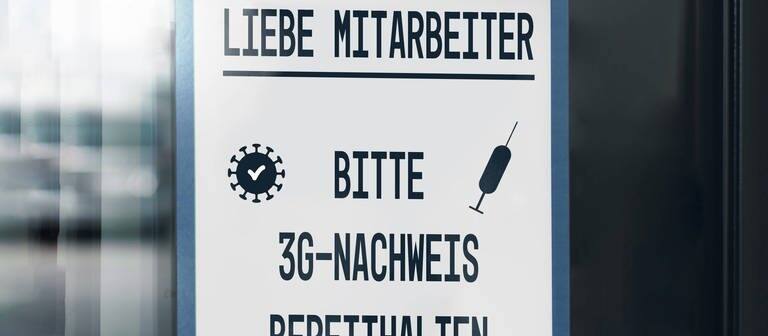 "Liebe Mitarbeiter, bitte 3G-Nachweis bereithalten", steht auf einem Schild. (Foto: IMAGO, imago images/Bihlmayerfotografie)