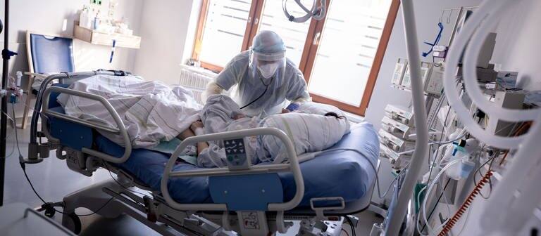 Ein Intensivpfleger arbeitet an einer Corona-Patientin (Foto: dpa Bildfunk, picture alliance/dpa | Kay Nietfeld)