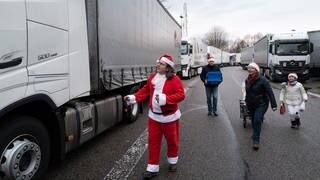 Juan Pedro Garcia Rosales in Weihnachtsmannkostüm und seine Helfer laufen mit Geschenken zu einem Lkw. (Foto: SWR, Christof Gerlitz)