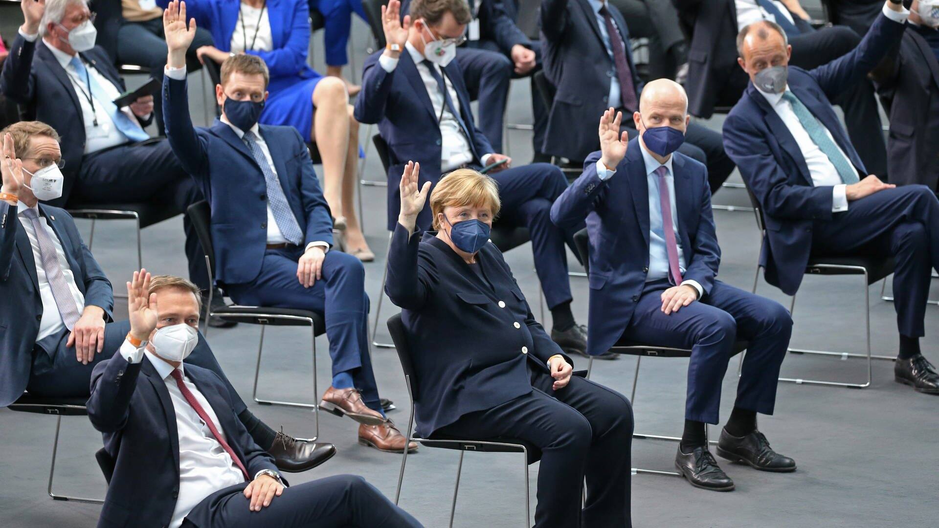 Angela Merkel (vordere Reiche, 2.v.l., CDU), ehemalige Bundeskanzlerin, sitzt bei der Bundesversammlung im Paul-Löbe-Haus zur Wahl des Bundespräsidenten und hebt die Hand. Links neben ihr sitzt Christian Lindner, Bundesvorsitzende der FDP und Finanzminister. (Foto: dpa Bildfunk, picture alliance/dpa/dpa-Zentralbild | Wolfgang Kumm)
