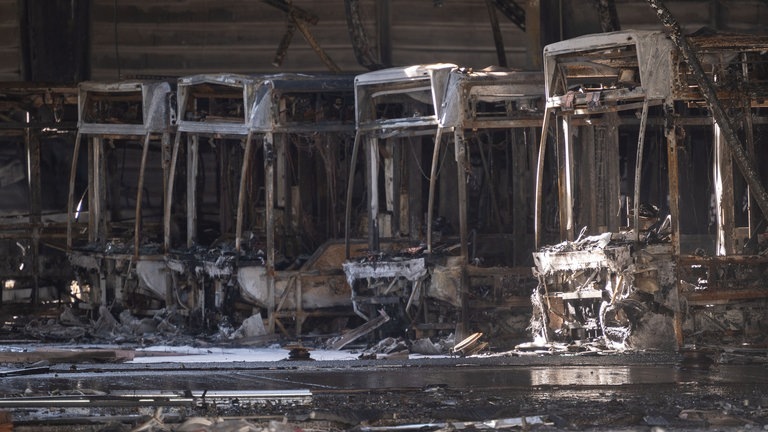 Ausgebrannte Omnibusse stehen in einem Busdepot. Nach einem Großbrand in dem Depot ist die Ursache des Feuers weiterhin unklar. (Foto: dpa Bildfunk, picture alliance/dpa | Marijan Murat)