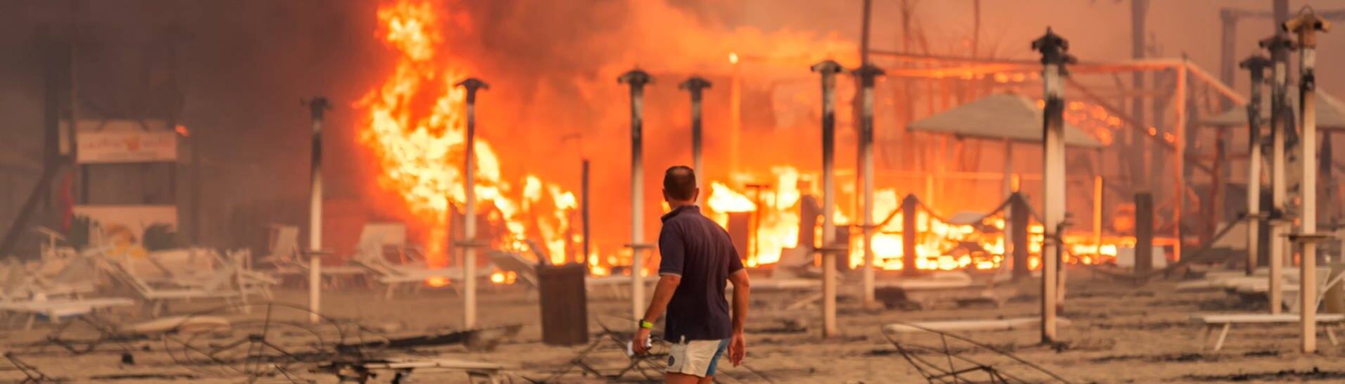 Ein Mann läuft und betrachtet den durch Feuer zerstörten „Le Capannine"-Strand in Catania auf Sizilien (Foto: Reuters)