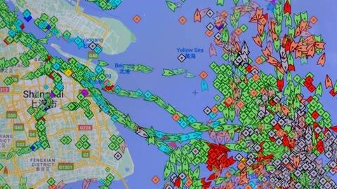 Auf einem Smartphone-Monitor ist die App «MarineTraffic» zu sehen, die die Positionen von Frachtschiffen (grün) vor dem Hafen von Shanghai anzeigt. (Foto: dpa Bildfunk, picture alliance/dpa | -)