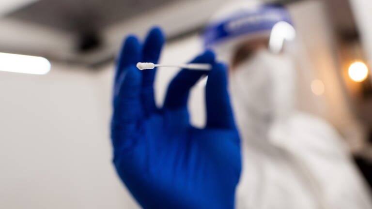 Medizinisches Personal mit Stäbchen für Corona-Test in der Hand (Foto: dpa Bildfunk, Picture Alliance)