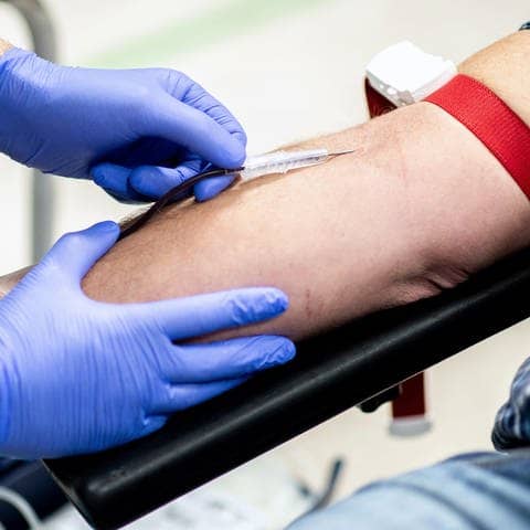Ein Mann hat bei einer Blutspende eine Nadel im Arm (Foto: dpa Bildfunk, picture alliance/dpa | Hauke-Christian Dittrich)