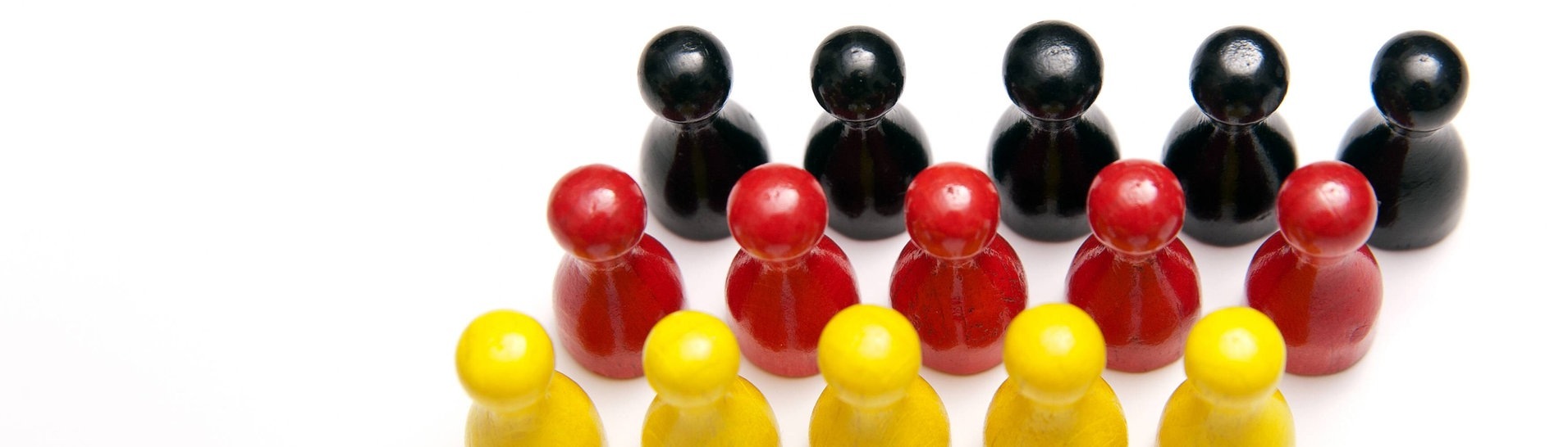Schwarze, rote und gelbe Spielfiguren sind zu einer Deutschlandflagge angeordnet. (Foto: IMAGO, imago stock&people)