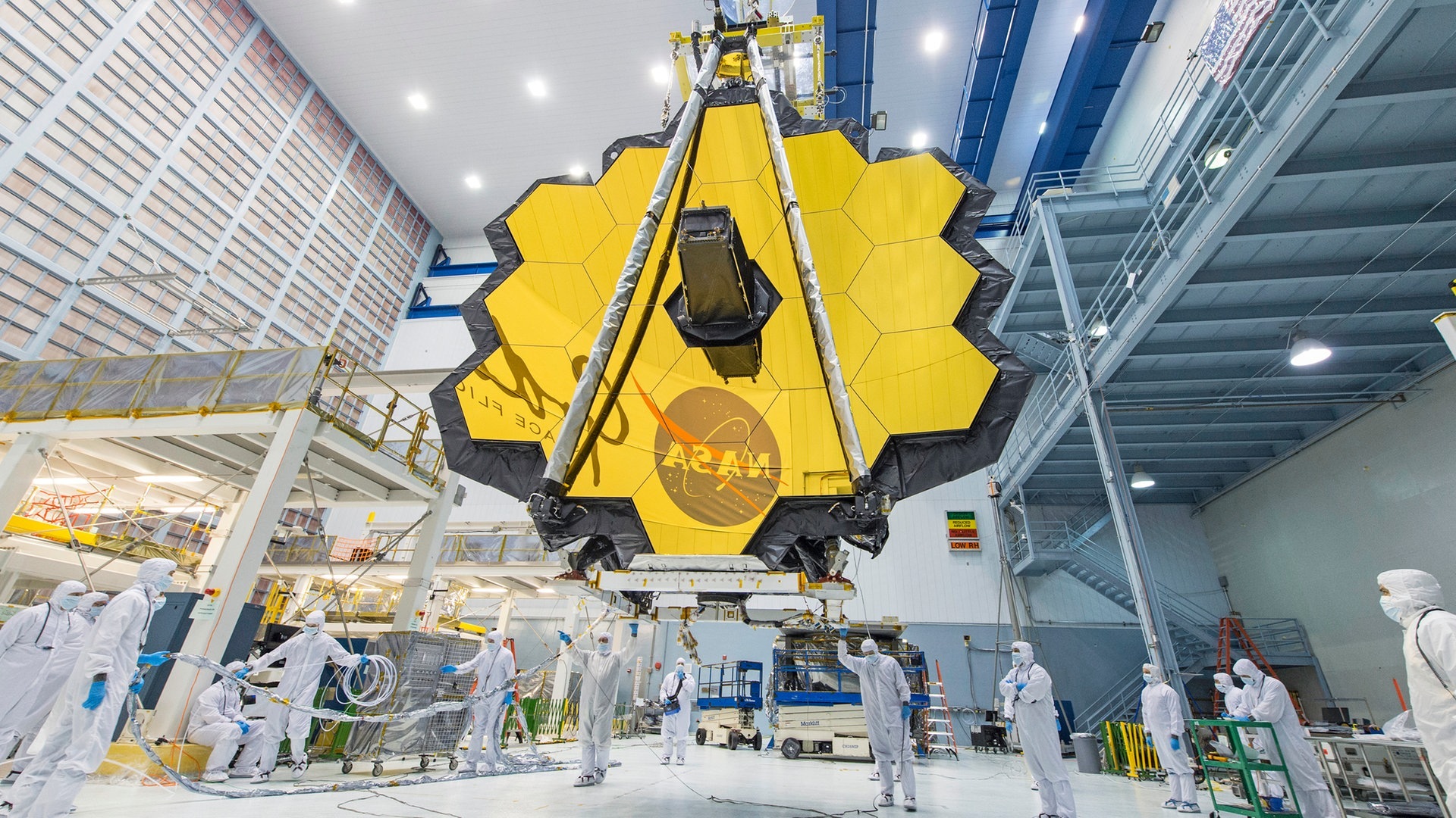 Foto: dpa Bildfunk, picture alliance/dpa/NASA/AP | Uncredited Dieses von der NASA zur Verfügung gestellte Foto zeigt Techniker, die die Spiegelbaugruppe des «James Webb»-Teleskops im Goddard Space Flight Center der NASA anheben. (Foto: dpa Bildfunk, picture alliance/dpa/NASA/AP | Uncredited)