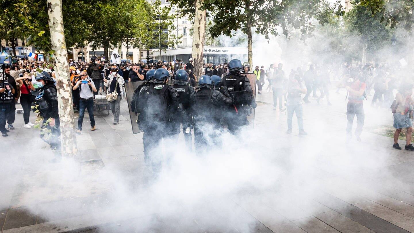 Tränengas zieht zwischen Polizisten und Demonstranten, die in Paris gegen die Corona-Maßnahmen protestieren. (Foto: IMAGO, IMAGO / Le Pictorium)