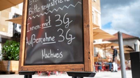 Vor einem Restaurant in Stuttgart steht ein Hinweisschild mit Infos zu den 3G-Regeln im Innenbereich. (Foto: dpa Bildfunk, picture alliance/dpa | Marijan Murat)
