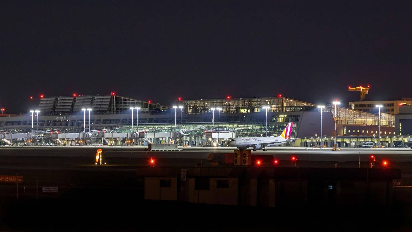 Ein Flugzeug steht bei Nacht am Terminal am Flughafen Stuttgart. (Foto: IMAGO, IMAGO / Arnulf Hettrich)