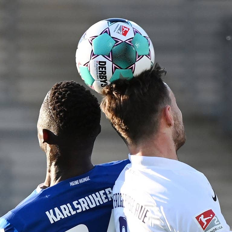 Der Karlsruher Babacar Gueye (l) und der Auer Florian Ballas kämpfen um den Ball. 