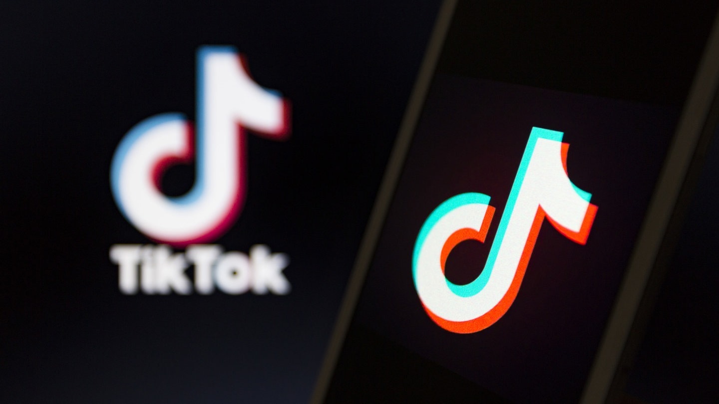 Das Logo von Tiktok ist auf einem Smartphone und ein weiteres Mal verschwommen im Bildhintergrund zu sehen. (Foto: dpa Bildfunk, picture alliance/Andre M. Chang/ZUMA Wire/dpa)