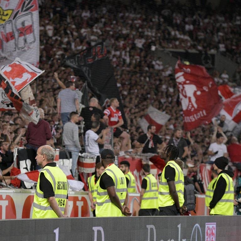Ordner stehen im Stuttgarter Stadion vor der Tribüne mit VfB-Fans (Foto: IMAGO, imago images / MIS)