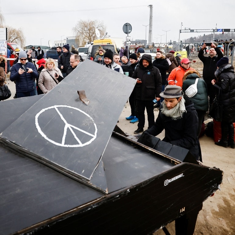Der Italiener David aus Deutschland spielt in Polen an der EU-Grenze zur Ukraine auf seinem Reise-Piano. (Foto: Reuters)
