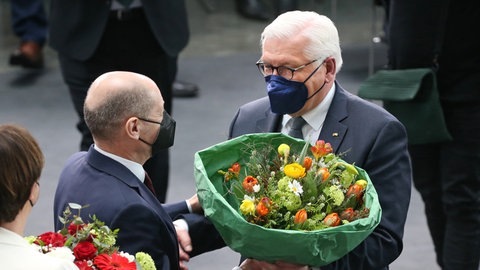 Bundespräsident Frank-Walter Steinmeier (r) bekommt nach der Verkündung des Ergebnis der Wahl des Bundespräsidenten durch die Bundesversammlung im Paul-Löbe-Haus Blumen von Bundeskanzler Olaf Scholz (SPD).  (Foto: dpa Bildfunk, picture alliance/dpa/dpa-Zentralbild | Wolfgang Kumm)