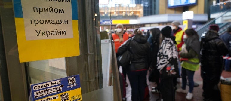 Ukrainische Flüchtlinge sprechen nach ihrer Ankunft am Hauptbahnhof mit Helfern des Arbeiter-Samariter-Bundes (ASB). Mitarbeiter und Freiwillige des ASB sowie Übersetzer nehmen die ukrainischen Flüchtlinge nach ihrer Ankunft am Hamburger Hauptbahnhof in Empfang. (Foto: dpa Bildfunk, picture alliance/dpa | Marcus Brandt)
