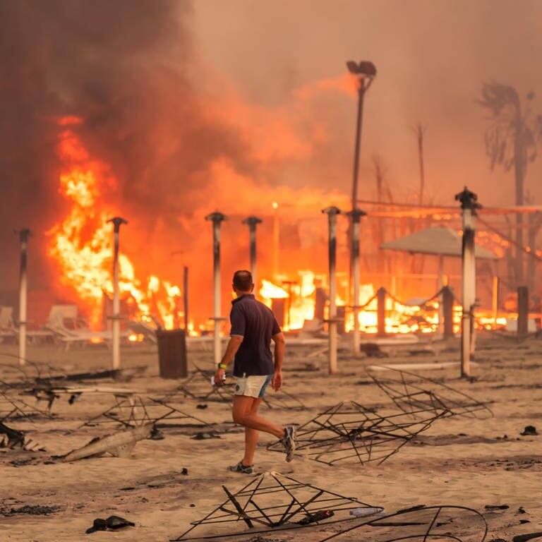 Ein Mann läuft und betrachtet den durch Feuer zerstörten „Le Capannine"-Strand in Catania auf Sizilien (Foto: Reuters)