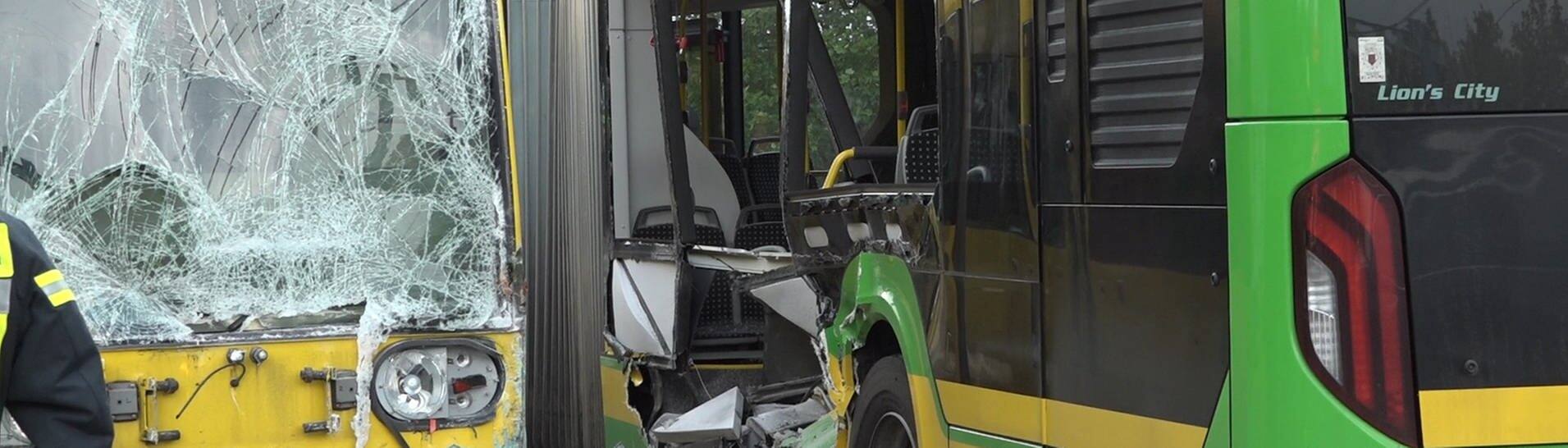 Die Straßenbahn links im Bild ist durch den Zusammenstoß mit einem Bus beschädigt. Rechts sieht man den Bus mit einer starken Delle, bei der die Scheiben herausgebrochen sind.  (Foto: dpa Bildfunk, picture alliance/dpa | Markus Gayk)
