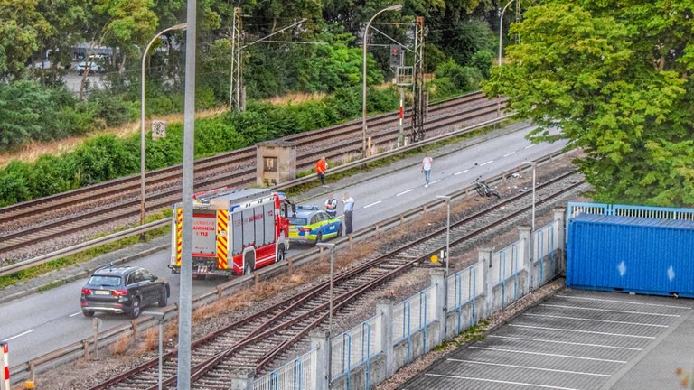 Am Unfallort liegt ein kaputtes Fahrrad und mehrere Einsatzfahrzeuge. (Foto: IMAGO, IMAGO / Einsatz-Report24)