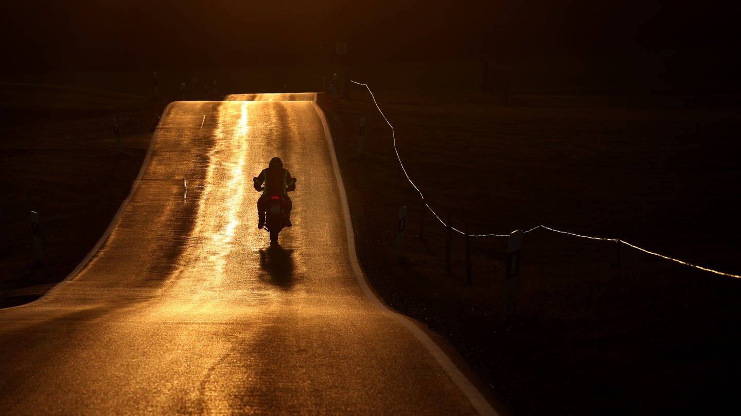 Motorradfahrer bei Sonnenuntergang (Foto: dpa Bildfunk, picture alliance/dpa | Karl-Josef Hildenbrand)