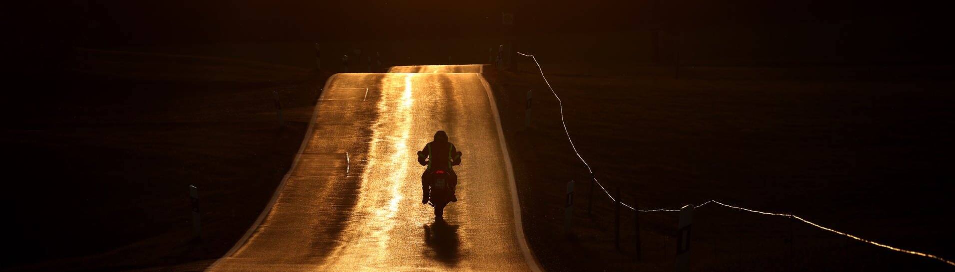 Motorradfahrer bei Sonnenuntergang (Foto: dpa Bildfunk, picture alliance/dpa | Karl-Josef Hildenbrand)
