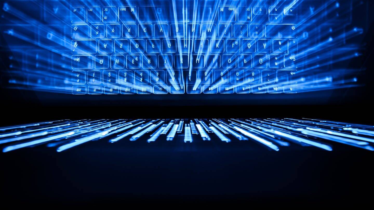 Die beleuchtete Tastatur eines Laptops spiegelt sich im Bildschirm. (Foto: dpa Bildfunk, picture alliance/dpa | Silas Stein)