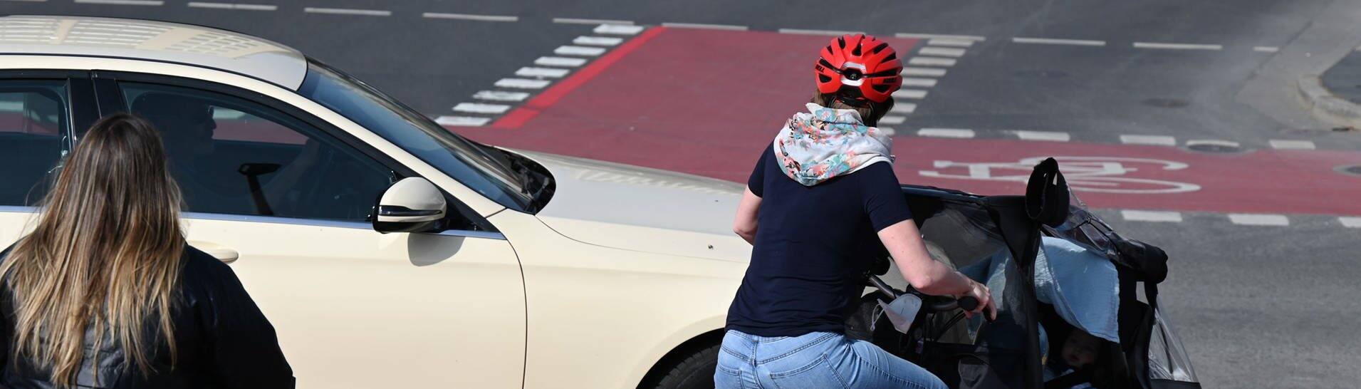 Ein Pkw blockiert an einer Kreuzung in der Frankfurter Innenstadt einen Fahrradstreifen, auf den rote Spezialmarkierungs-Kaltplastik aufgetragen ist.  (Foto: dpa Bildfunk, picture alliance/dpa | Arne Dedert)