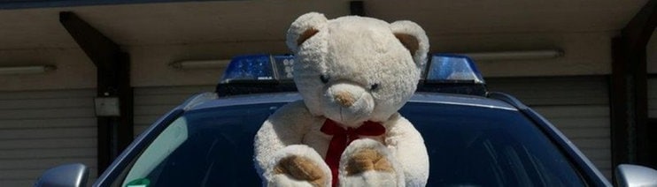 Ein Plüsch-Teddybär sitzt auf der Motorhaube eines Streifenwagens. (Foto: Pressestelle, Polizei Mannheim)