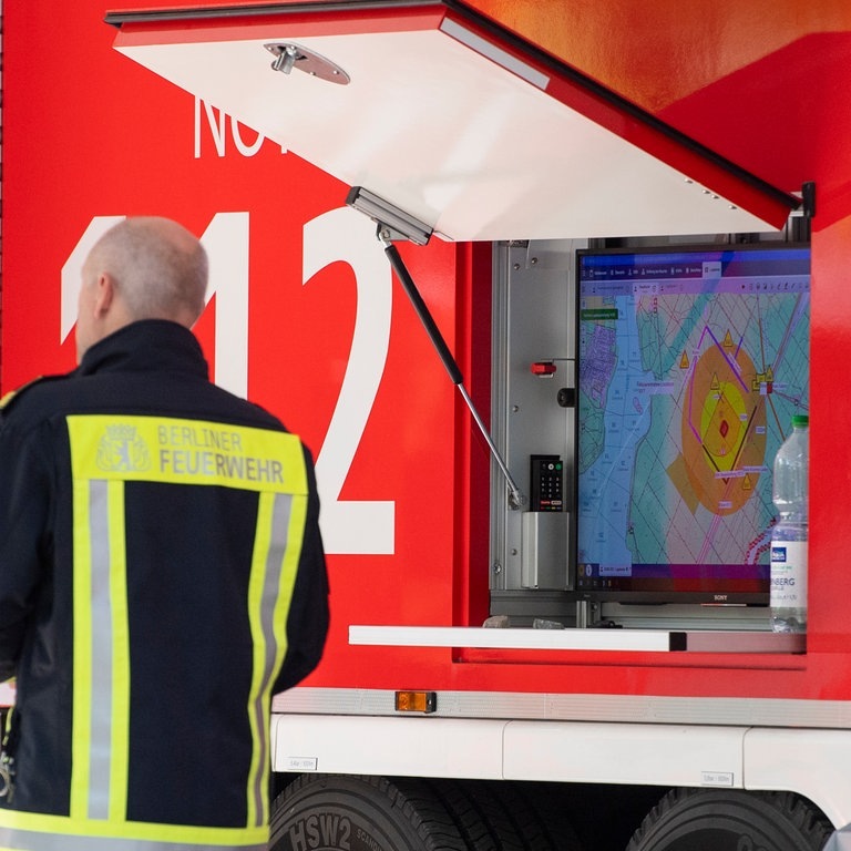 An einem Fahrzeug der Einsatzleitung der Feuerwehr ist eine Karte mit dem Sperrkreis angezeigt. (Foto: dpa Bildfunk, picture alliance/dpa | Christophe Gateau)